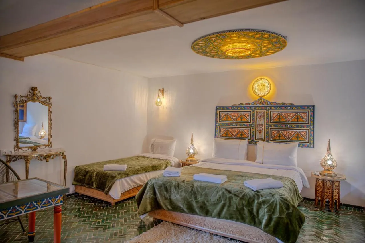 Double guest room with green textiles and carved details